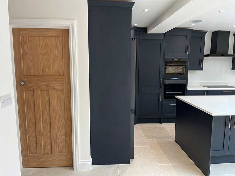 Dark navy shaker kitchen with an island and oak internal door