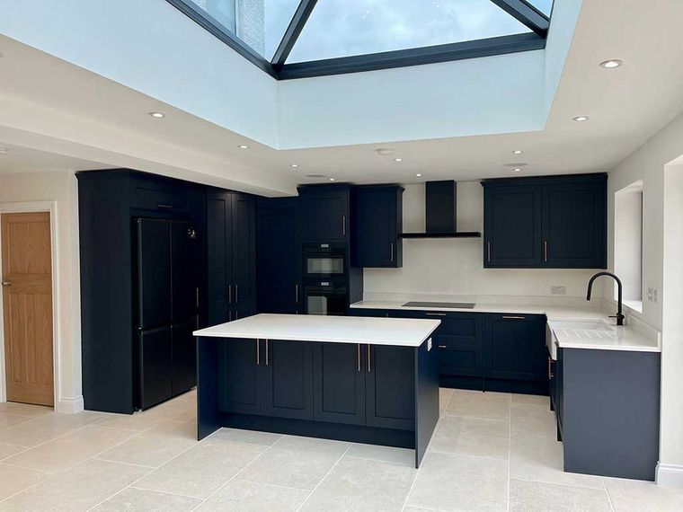 Navy kitchen with an island beneath a lantern roof