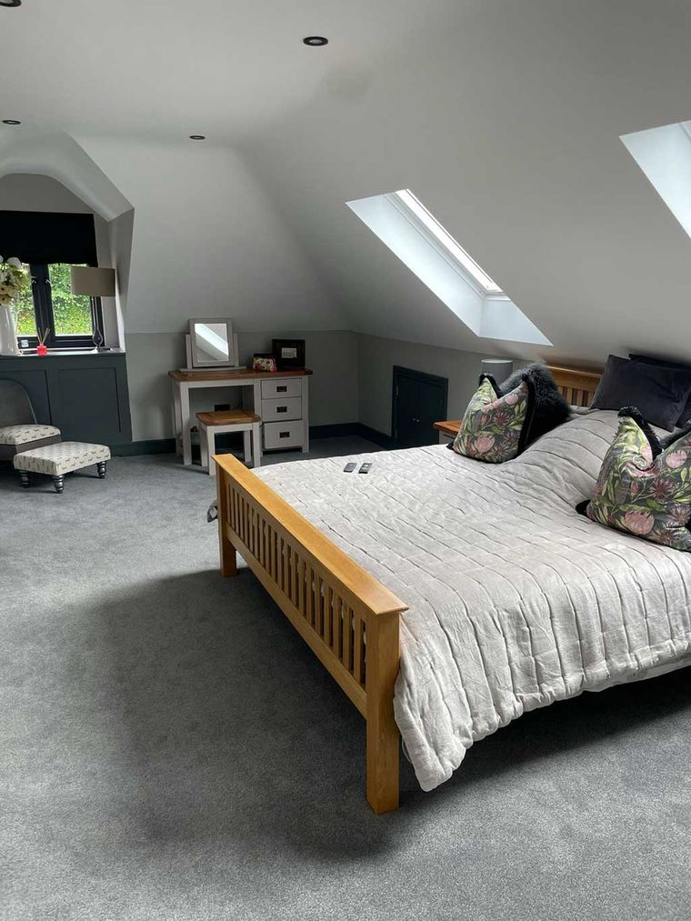 Loft conversion bedroom with a sloping ceiling and rooflights
